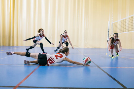Competitive female volleyball team failing blocking ball while tournament in Madrid, Spain.
