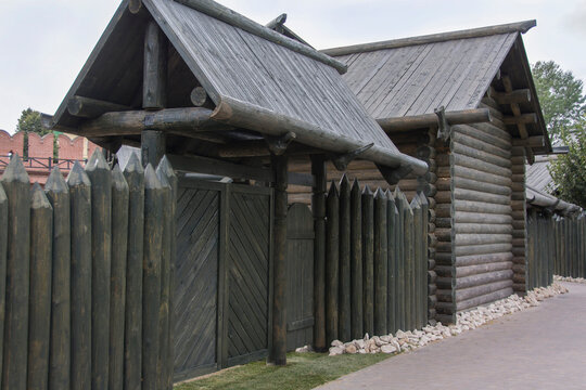 medieval gate and a house made of dark wooden logs