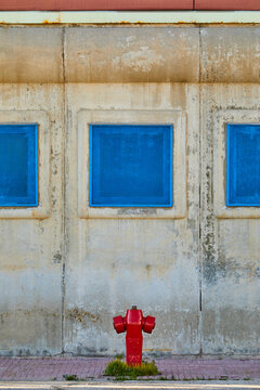 Red fire hydrant at old wall with blue window