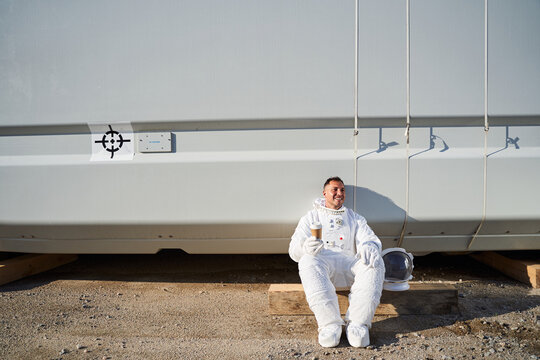 Happy astronaut drinking coffee
