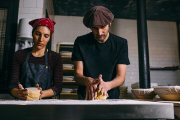 Cheerful bakery workers making bread