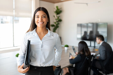 Hispanic female business professional in office boardroom - Powered by Adobe