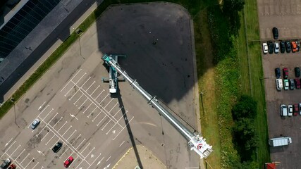 The tallest and largest mobile truck crane with extended boom. Following the full length of the boom of a mobile crane, aerial top view.