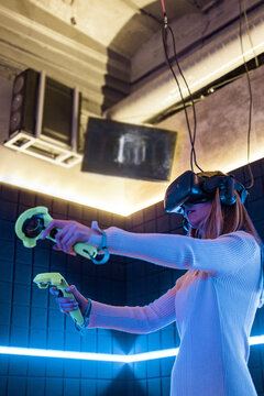 Woman enjoying vr gaming in an indoor arcade
