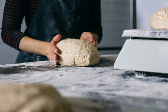 Baker weighing dough on scales