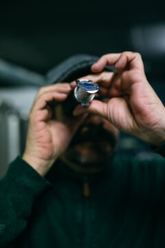 Brewer examining beer in refractometer