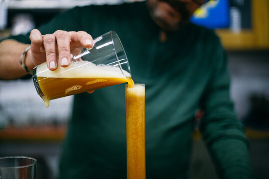 Blurred brewer pouring beer into tube