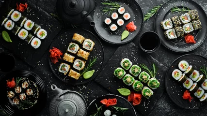 Foto auf Acrylglas Set of traditional sushi on a black plate. Sushi and rolls on a dark background. © Yaruniv-Studio