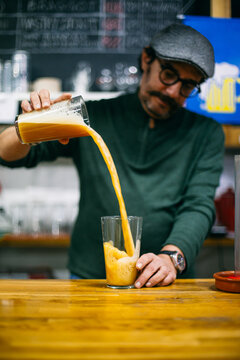 Blurred brewer pouring beer into tube