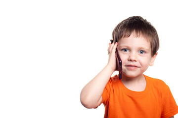 A small boy with a phone on a white background. Boys phone. The children of today . Connection with the child. Benefits and harms of phones .