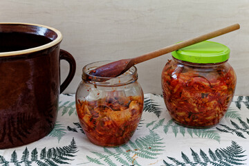 Transferring ready kimchee to glass jars using wooden spoon. Korean healthy cuisine. Traditional food recipe.