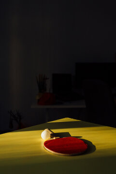 A Racket And Ping Pong On A Yellow Desk