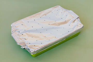Ceramic dish covered with aluminum foil with little holes. Preparation of natto (soybean) fermented...