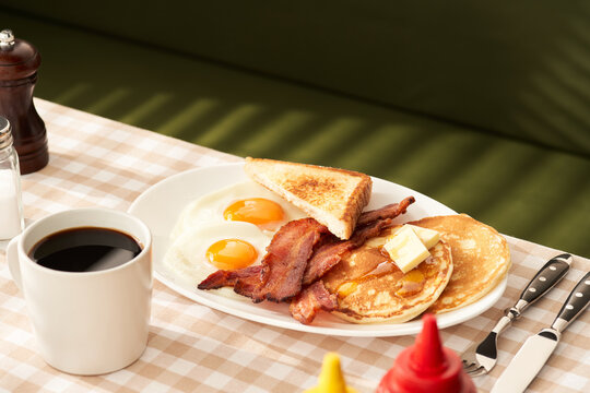 Typical American breakfast on table with checkered cloth