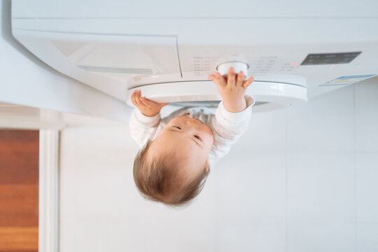 baby playing washing machine at home