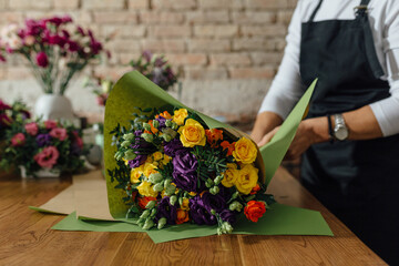 Woman Wrapping Flower Bouquet In Kraft Paper