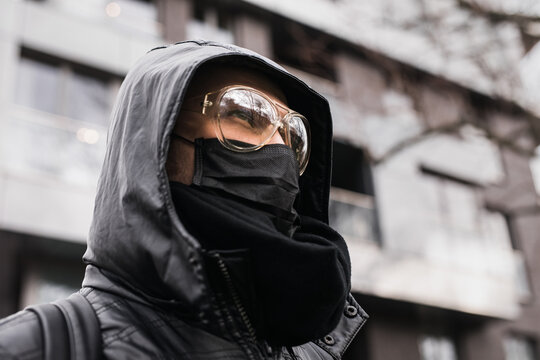 Man wearing black medical mask and goggles outside