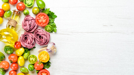 Dry pasta with colored tomato oil and parsley. Italian traditional cuisine. Fresh vegetables. Top view. Free space for your text.