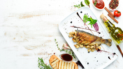 Grilled trout with mushrooms on a plate. Top view. Free copy space.