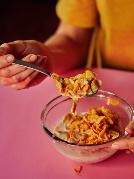 Corn flakes with milk breakfast meal on pink