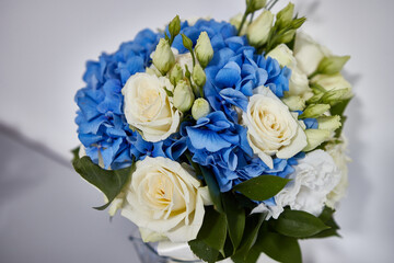 Exquisite bouquet of white roses and blue flowers