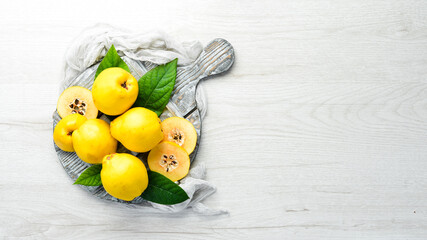 Fresh quince fruits on a wooden board. Top view. Free space for text.