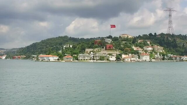 Waterside residences Adile Sultan Palace with Turkish flag along Bosporus Sea. Istanbul, Turkey.