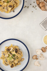 Homemade Italian fettuccine pasta with mushrooms and parmesan (Fettuccine al Funghi Porcini). Traditional Italian cuisine. Served on white background. Top view.