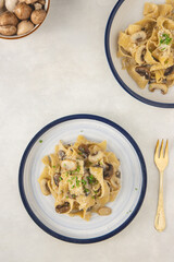 Homemade Italian fettuccine pasta with mushrooms and parmesan (Fettuccine al Funghi Porcini). Traditional Italian cuisine. Served on white background. Top view.