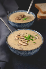 Homemade mushroom cream soup. Served on a dark background. Close-up.