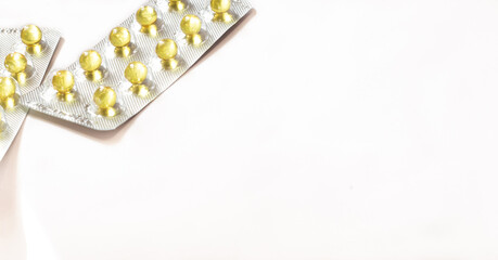Pack of yellow vitamins lies on a white background with copy space available. Medicine concept