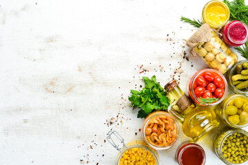 Background of food stocks in glass jars. Pickled vegetables and mushrooms. Top view.