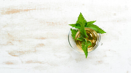 Nettle tea in cups on a white background. Herbal healthy drinks. Top view. Free space for your text.