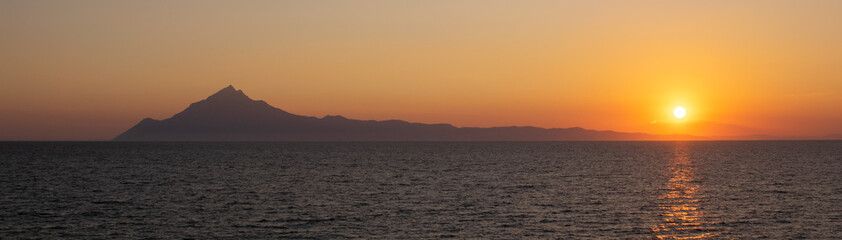 Panorami view of Athos mountain in Greece seen from the Mediterranean Sea at sunset