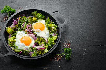 Vegetable Shakshuka in a pan. Fried eggs with vegetables: broccoli, green peas, beans, onions. Top view. Free space for your text.