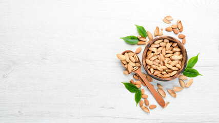 Nuts. Almonds on a white wooden table. Top view. Free space for your text.