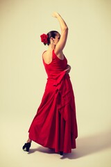 woman with red dress and red flower dancing flamenco sevillanas