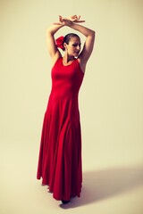 woman with red dress and flower dancing sevillanas and flamenco