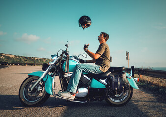 Biker on a motorcycle tossing the helmet in the air