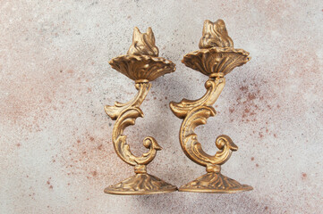 Antique candlesticks on concrete background.