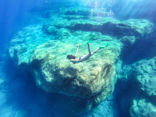 Mermaid girl swimming under the surface diving in Greece