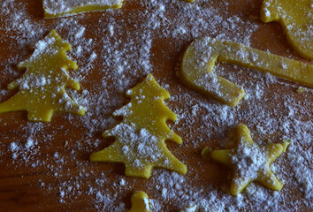 Shortbread cookies of different shapes on a wooden table with flour. Cooking, baking.