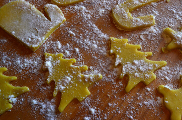 Shortbread cookies of different shapes on a wooden table with flour. Cooking, baking.