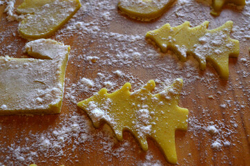 Shortbread cookies of different shapes on a wooden table with flour. Cooking, baking.