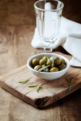 Green olives on rustic wooden background. 