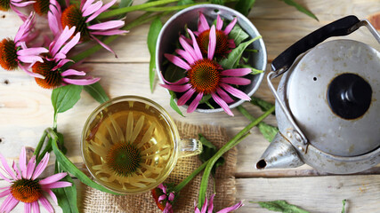 Echinacea flowers and echinacea drink on a wooden surface. Top view. Healing herbs.