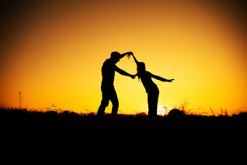 Fototapeta na wymiar Young couple enjoying the sunset in the meadow. Couple in love. 