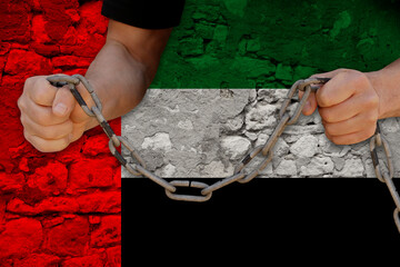 male hands breaking the iron chain, symbol of bondage, protest against background of state flag of...