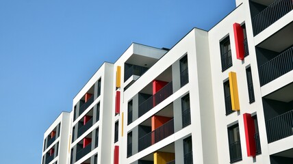 Contemporary residential building exterior in the daylight. Modern apartment buildings on a sunny day with a blue sky. Facade of a modern apartment building