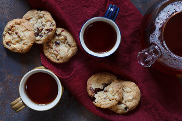 Teapot, tea in a mug and tasty homemade cookies, top view